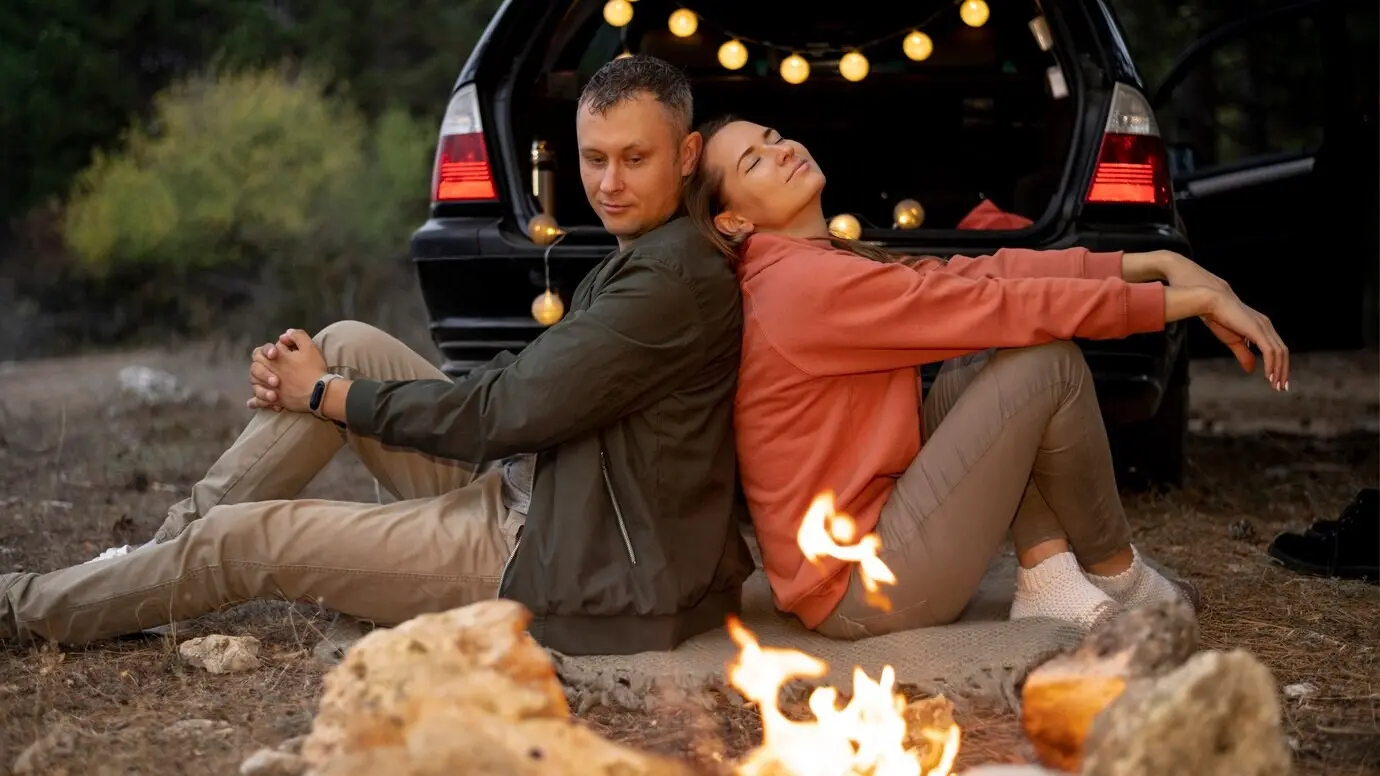 Entzückendes Paar, das ein Lagerfeuer genießt