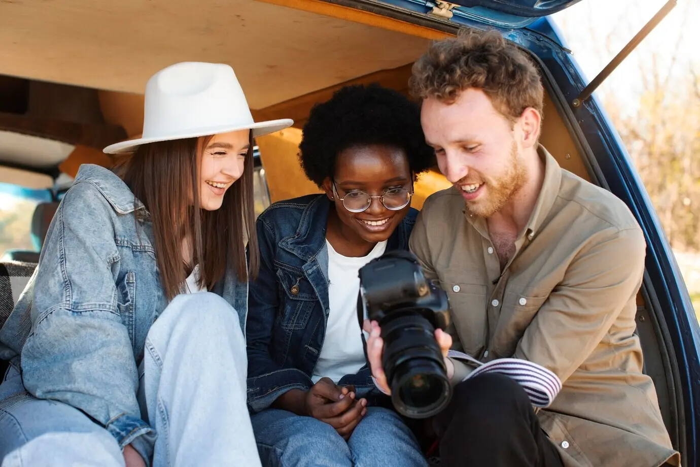 Halbnahe Aufnahme von Freunden, die sich Fotos anschauen.